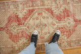 Overhead view highlighting the worn texture and scale of a distressed Oushak runner.