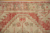 Close view of the low-pile texture and visible knot heads on a distressed Oushak rug.