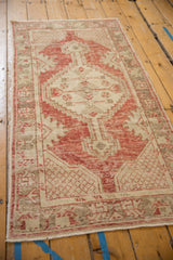 Angled perspective of a distressed Oushak runner with brick red and ivory geometric motifs.