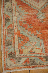 Vintage Oushak rug corner, showing distressed brick red pile, pale blue motifs, and side selvage.