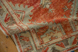 Worn texture and geometric patterns on a vintage Oushak rug in faded red, blue, and beige.