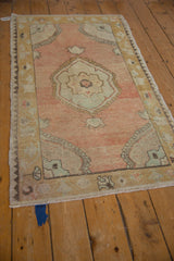 Angled view of the distressed Oushak's corner, highlighting the unique charcoal zig-zag reciprocal border.