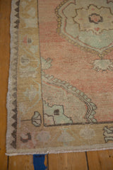The unique zig-zag reciprocal border and distressed low pile on a vintage Turkish Oushak rug.