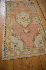Floral medallion and gold borders on an abrashed dusty rose vintage Oushak rug.