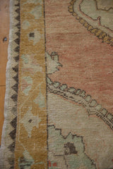 Unique zig-zag reciprocal border on a vintage Oushak rug in gold and charcoal tones.