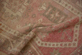 Textured pile of vintage distressed Oushak rug with heavy abrashes and shifting red shades.