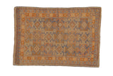 Vintage distressed Anatolian rug, geometric diamonds in faded blue and gold, with visible foundation.