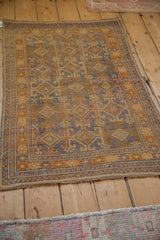 Distressed Anatolian rug's fringe and checkered border with faded blue and gold patterns.