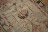 Distressed vintage Oushak rug detail, revealing worn pile, beige, blush and brown patterns.