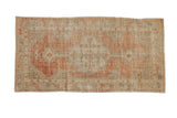 A distressed vintage Oushak rug runner with a stepped medallion in pale rust, ivory, and sea foam tones.