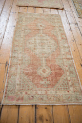 A full perspective of the distressed Oushak runner highlighting its time-softened rust and sea foam colors.