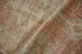 Close-up view of the low pile and distressed texture on a vintage Oushak rug runner.