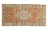 Distressed vintage Oushak runner with dusty terracotta field, roundel floral medallion, and ivory borders.