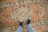 Distressed Oushak runner with faded terracotta, ivory tones, roundel medallion, and visible wear.