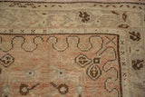 Distressed vintage Oushak rug, showcasing abrash texture, ribbon vines, and soft blush tones.
