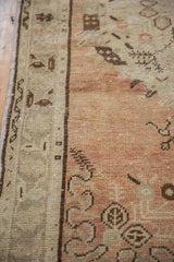 Distressed Oushak rug detail: abrash on dusty terracotta field, tan border, brown geometric motifs.