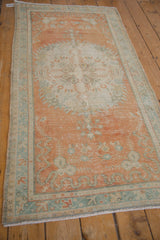 Distressed texture and floral design on tangerine orange and ivory vintage Oushak rug.