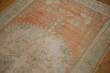 Distressed vintage Oushak rug texture, showing faded tangerine orange, ivory, and ocean blue colors.