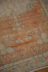 Decorative wear and patterns in pale tangerine and ocean green on vintage Oushak rug.