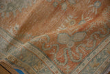 Distressed vintage Oushak rug with a pale tangerine field and ocean green meandering vine spandrel.