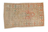 Distressed Oushak rug with a geometric diamond medallion and floral motifs in soft orange, sage, and ivory.