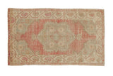 Vintage distressed Oushak rug with a central quatrefoil medallion in soft magenta, ivory, and pale slate blue.