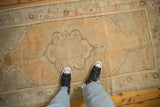 Soft low pile of a distressed Oushak runner with a pale gold field and muted silver medallion.