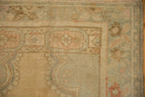Detail of the Oushak rug's corner, featuring the blossoming floral border and low-pile texture.