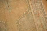 Detail of a distressed Oushak's corner showing the low pile and scalloped pattern in oxidized silver.
