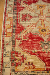 Distressed pile and knot heads on a vintage Turkish Oushak rug in cherry red and gold.