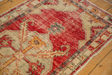 Detail of serrated leaf motifs on the distressed, time-softened pile of a vintage Oushak rug.