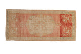 Distressed Oushak runner with a faded pink medallion field and a contrasting, stylized red end panel.