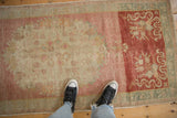 Heavily abrashed ground of a vintage Oushak runner showing varied dye lots in pink, red, and ivory.
