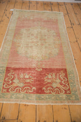 An angled view showing the full length and abrashed texture of a vintage Oushak rug runner.