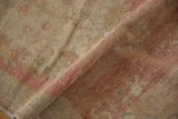A fold highlights the evenly worn pile of the vintage Oushak runner in soft pink and beige.