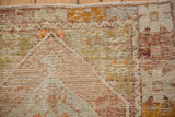 Textural distressed Oushak rug pile showcasing ivory, gold, pale orange, lime green, and fringe.