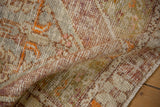 Distressed Oushak rug pile, showing worn texture with aubergine and tangerine hues.