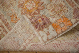 Worn pile texture and hand-knotted foundation of a distressed Oushak rug.