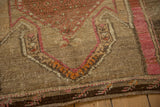 Distressed Kars rug showing heavy abrashes, finned leaf border, and pink-orange geometric motifs.