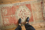 A personal perspective of the distressed Oushak runner, highlighting its scale and worn texture.