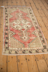 Distressed Oushak runner corner with faded cherry red, ivory lattice spandrels, celadon patterns.