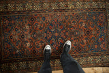 Antique Hamadan rug with allover Herati design, madder red, sapphire blue, and notable wear.