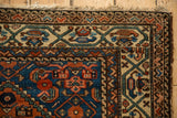 Antique Hamadan rug upper corner: Herati spandrel, vine border, sapphire, madder red, tattered fringe.