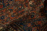 Rich madder red and sapphire blue Herati motif on folded antique Hamadan rug.
