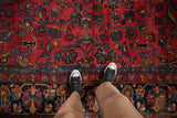 Vintage Persian Hamadan carpet, raspberry red field with gem-toned floral sprays, navy blue border.