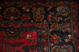 Nuanced floral sprays on the Hamadan carpet's navy field and ruby red border details.