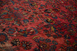 Ruby red field with nuanced floral sprays and sapphire blue motifs on a vintage Hamadan rug.