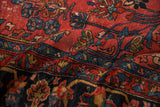 Persian Hamadan carpet detail with ruby red field, navy border, delicate floral sprays and localized wear.