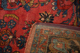 Vintage Hamadan rug showing raspberry red field, blue florals, foundation, and machine binding.