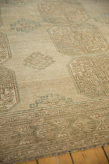 Distressed Ersari carpet with geometric guls, abrashed beige and dusty teal hues.